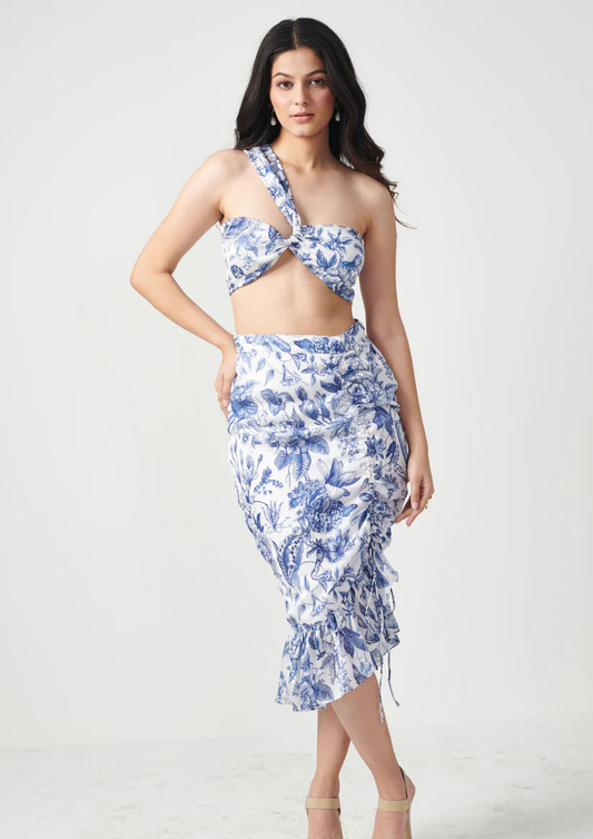Siora floral printed co-ord set featuring a one-shoulder crisscross crop top and ruffle skirt—ideal for resort wear and casual getaways.