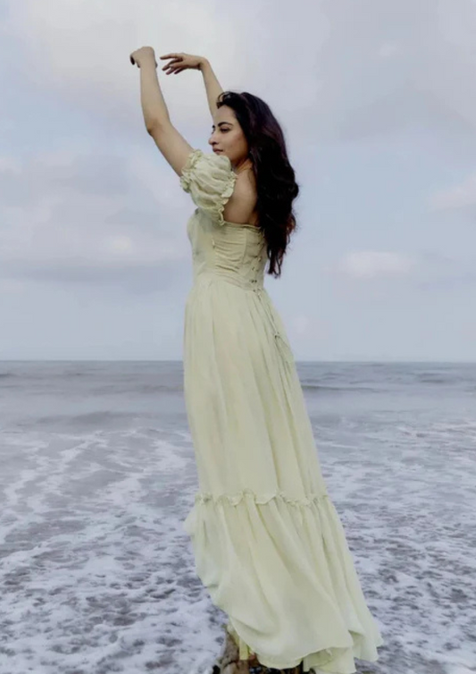 Theresa Long lime gown featuring structured bustier bodice, long flared layers, and criss-cross tie back—ideal for destination events and glamorous soirées.