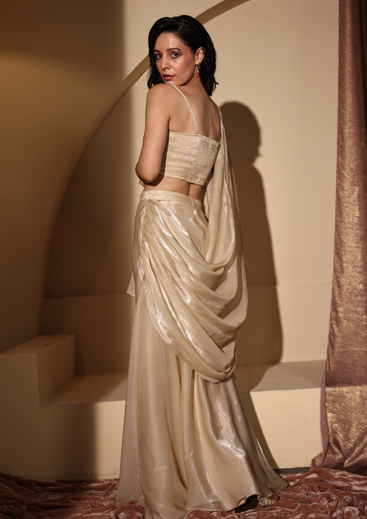 Seora Luxe statement gold Aylin Saree, designed with a luxurious tissue-draped finish, flared skirt, and a dazzling sequined bustier with ruched back—ideal for festive occasions, sangeet functions, and cocktail events.