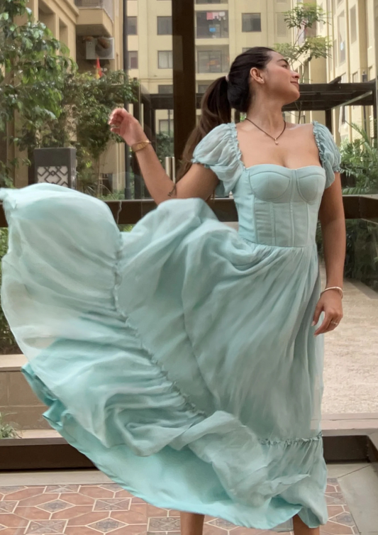 Marine Serenade aqua gown featuring bustier bodice, long flowing layers, and delicate puff sleeves—perfect for formal dinners, resort parties, and bridal occasions.